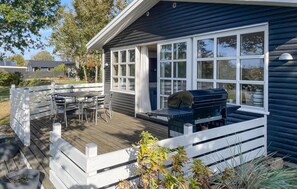 A deck with a grill and a table, surrounded by a white fence. - Beautiful home in Millinge with WiFi (Millinge)
