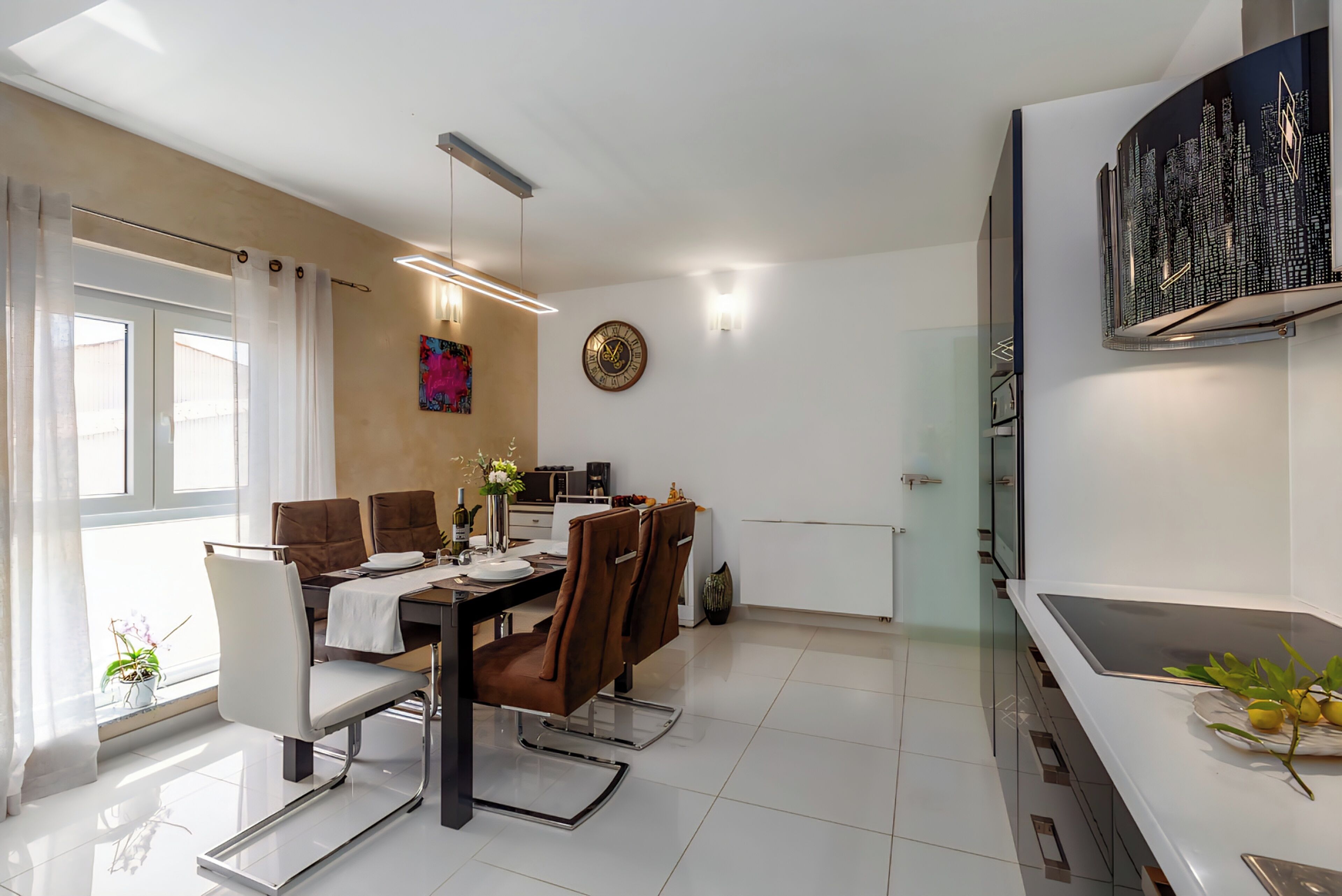 A modern dining area with a white table, brown chairs, and a cityscape artwork on the wall.