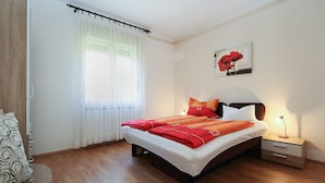 A neatly arranged bedroom with a bed, bedside table, lamp, and a painting on the wall. - Apartment 2411/167402 (Istria - Liznjan), 1500m from the beach (Liznjan)
