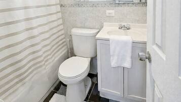 Een haardroger, handdoeken, zeep, toiletpapier