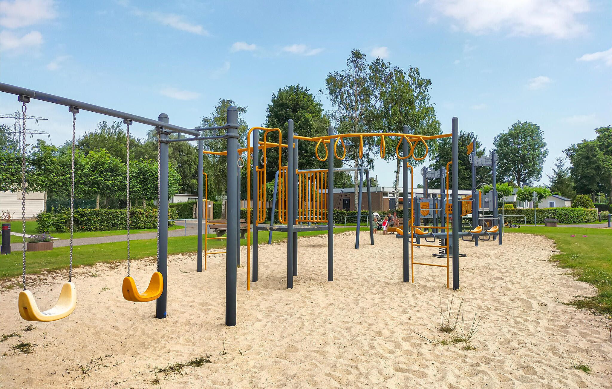 Ein Spielplatz mit Schaukeln und Klettergeräten.