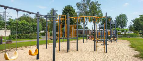 Ein Spielplatz mit Schaukeln und Klettergeräten.