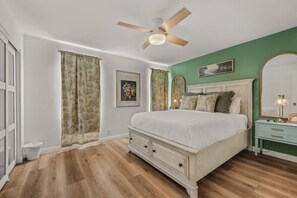 A bedroom with a bed, a nightstand, a dresser, a ceiling fan, and a large mirror. - Rooftop View, Spacious Yard, 19 min Disney, OR3 (Orange)
