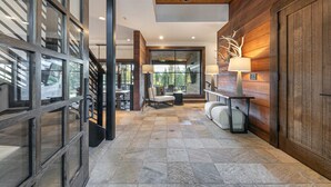A spacious hallway with a wooden ceiling, a large window, and a bench. - Monthly Lease - Ambiance at Martis Camp by Tahoe Getaways - 4BR w/ Hot Tub & Bonus Room (Truckee)