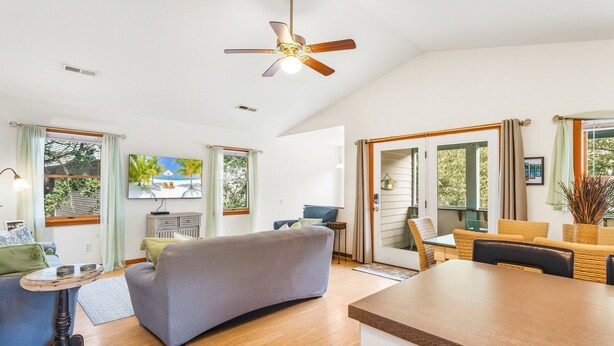 Un amplio espacio habitable con sofá, mesa de comedor y área de cocina.