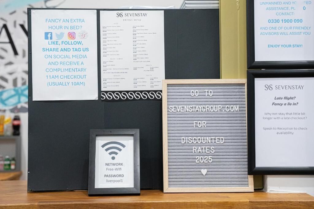 A framed signboard with a Wi-Fi symbol, a framed menu, and a framed promotional sign for discounted rates.