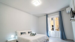 Une chambre à coucher avec un lit, une table de chevet et une fenêtre avec des rideaux.