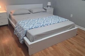 A bedroom with a bed, a nightstand, and a bedside lamp.