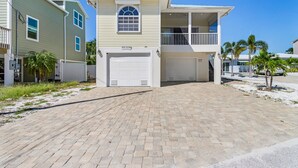 A two-story house with a garage, a balcony, and a small porch. - Private Heated Pool | Spacious 3BR House (Fort Myers Beach)