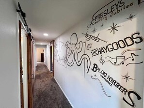 A hallway with a wall mural featuring text and abstract designs.