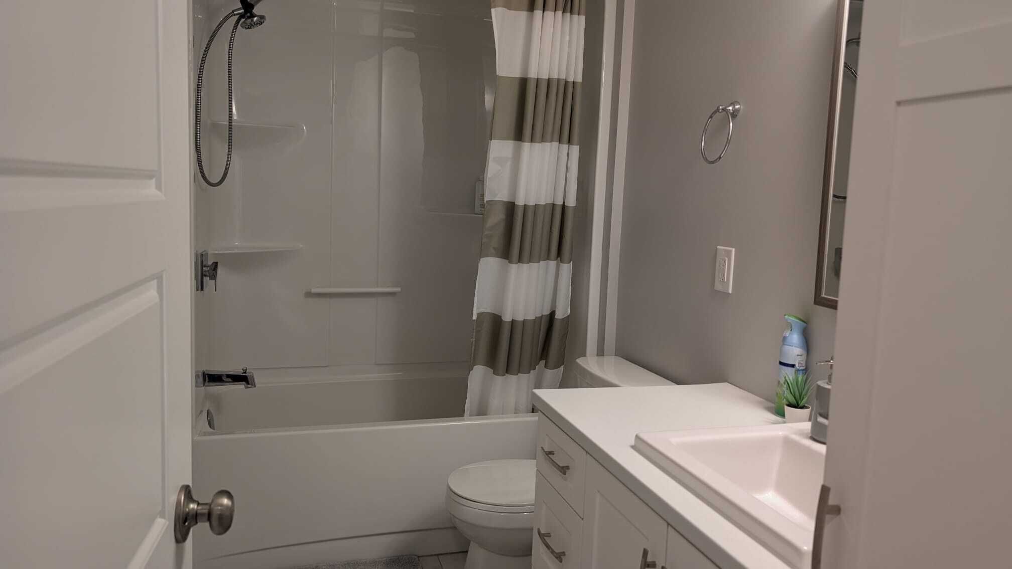 Ein kleines Badezimmer mit Dusche, Toilette und Waschbecken.