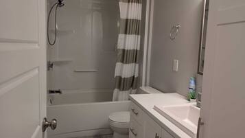 Ein kleines Badezimmer mit Dusche, Toilette und Waschbecken.