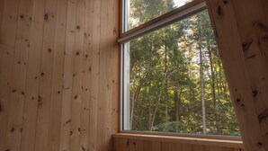 A wooden cabin room with a bed, a window, and a tray with a pot and cups. - Chalet Saison | Nature • Sauna - Hiking - Softness (Chertsey)