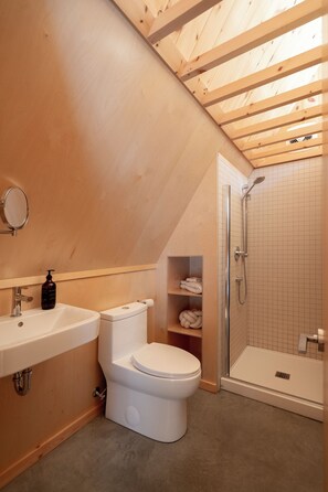 A bathroom with a wooden ceiling, a toilet, a sink, and a shower. - Chalet Saison | Nature • Sauna - Hiking - Softness (Chertsey)