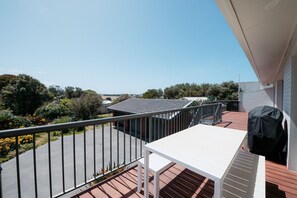 Un balcon donnant sur un jardin et un immeuble situé de l’autre côté de la rue.