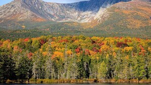 A mountainous landscape with a forested area in the foreground and a lake at the base. - New 2026 RV / Mountain View / ATVs (Lincoln)