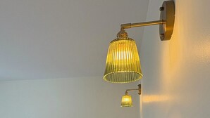 Ein Schlafzimmer mit einem Bett, einem Nachttisch und einer Wandlampe.