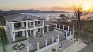 Une maison moderne à deux étages, dotée d’un balcon, d’une allée et d’un jardin clos.