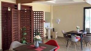 A dining area with a table, chairs, and a decorative plant. - TJ'S Boutique Hotel Eldoret (Eldoret)