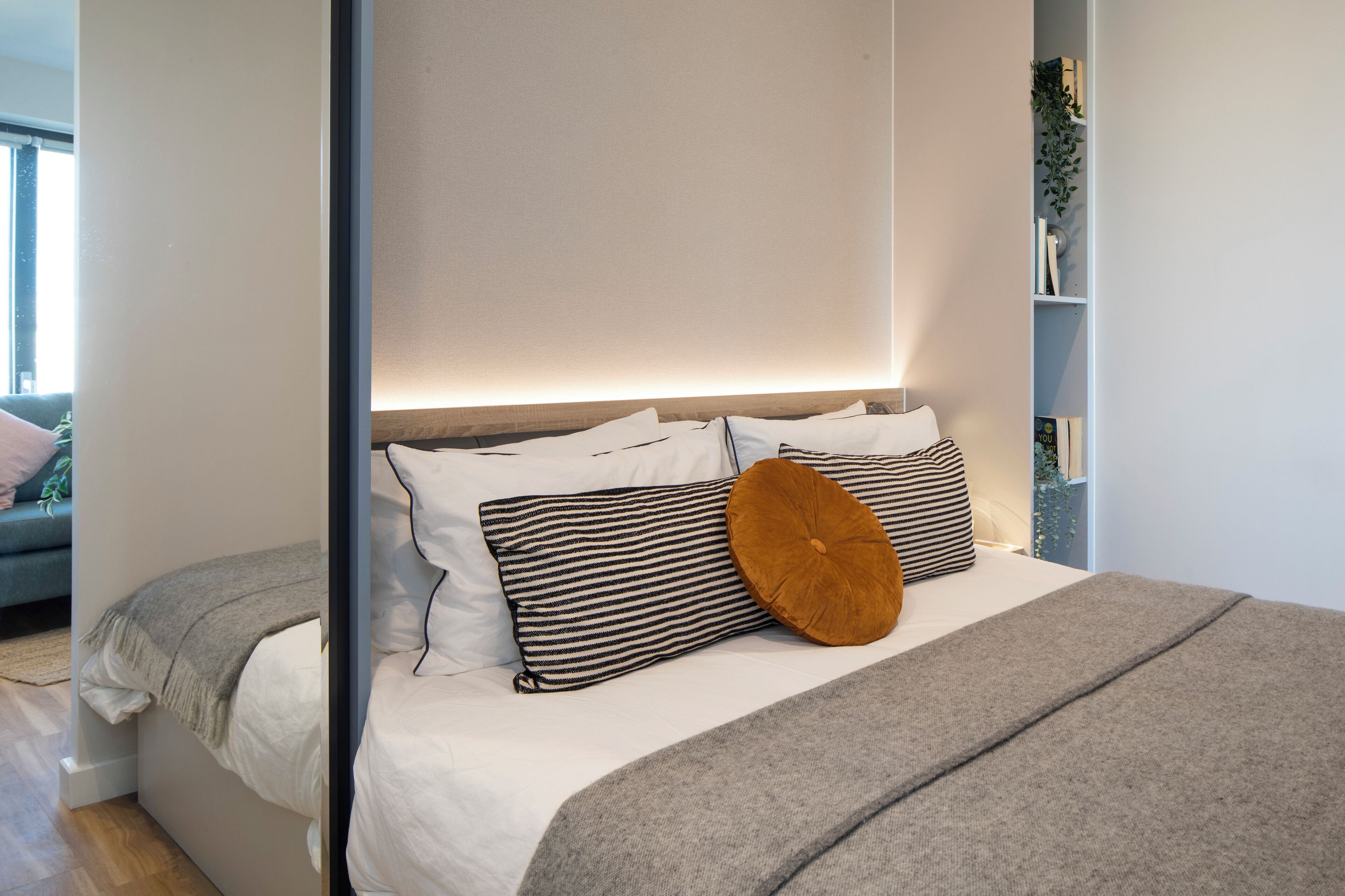 Un dormitorio moderno con una cama, almohadas y una mesita de noche.