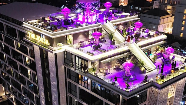 A multi-story hotel with a rooftop bar featuring outdoor seating and a staircase leading to the upper levels. - The Jogja Hotel & Conference Center - Malioboro (Yogyakarta)