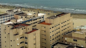 A coastal view with a beach and a row of multi-story buildings. - Modern Flat in Gonzaga, just a block from the beach. (Santos)