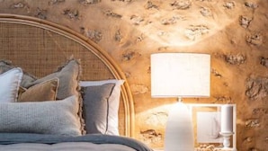 A bedroom with a bed, nightstand, and lamp.