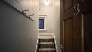 A staircase with patterned carpet leading to a door marked with the number 3. - NH3 - Historic Charm - Cozy 3BR Apartment (DuBois)