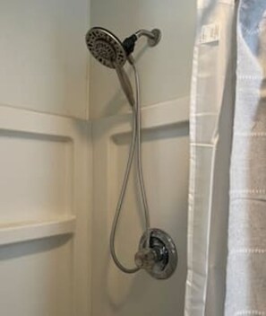 Eine Dusche mit Handbrause und Wandarmatur.