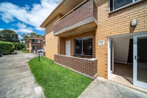 A two-story residential building with a brick facade, a balcony, and a sliding glass door. - Casa Boho—Peaceful Stay in Vibrant, Central Locale (Everard Park)