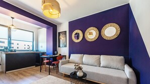 Un salon moderne comprenant un canapé, une table basse et un coin repas avec une table et des chaises.