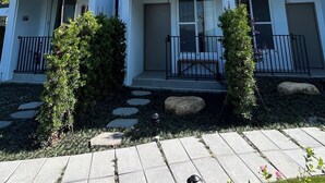 A modern three-story residential building with balconies, a front porch, and a well-maintained garden. - KUMOYOKU B&B (Taichung)