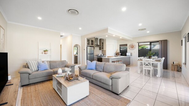 Un salon moderne avec deux canapés, une table basse et un coin repas comprenant une table et des chaises.