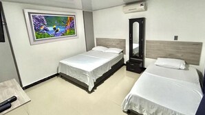 Een hotelkamer met twee eenpersoonsbedden, een grote spiegel, een airconditioning en een schilderij aan de muur.