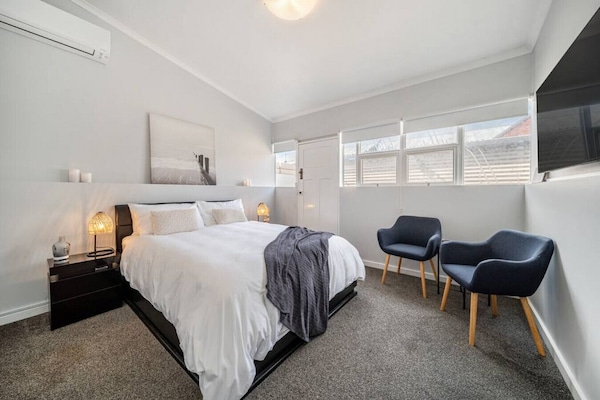 Sleep well on the queen-sized bed, plush carpet underfoot, soft linen, bedside lighting, and a north-facing window that fills the room with morning sunshine.