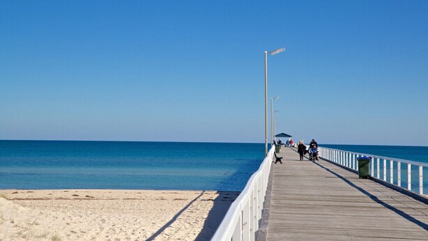 A wooden pier extending into the sea with a clear sky. - Urban Beach Shack - Steps to Grange Beach & Café (Grange)