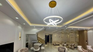 A modern living room with a TV, sofas, a dining area, and a staircase. - villa with garden in continental COMP (Sheikh Zayed City)