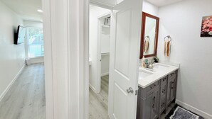 A bathroom with a white vanity, a mirror, and a sink. - Arlington Entertainment District Home Orange Door (Arlington)