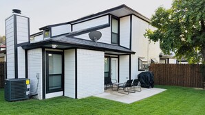 A modern two-story house with a covered patio, a satellite dish, and a large window. - Arlington Entertainment District Home Orange Door (Arlington)