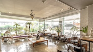 A spacious lobby with a seating area, large windows, and a statue. - FORTUNE HOTEL (Xinyi)