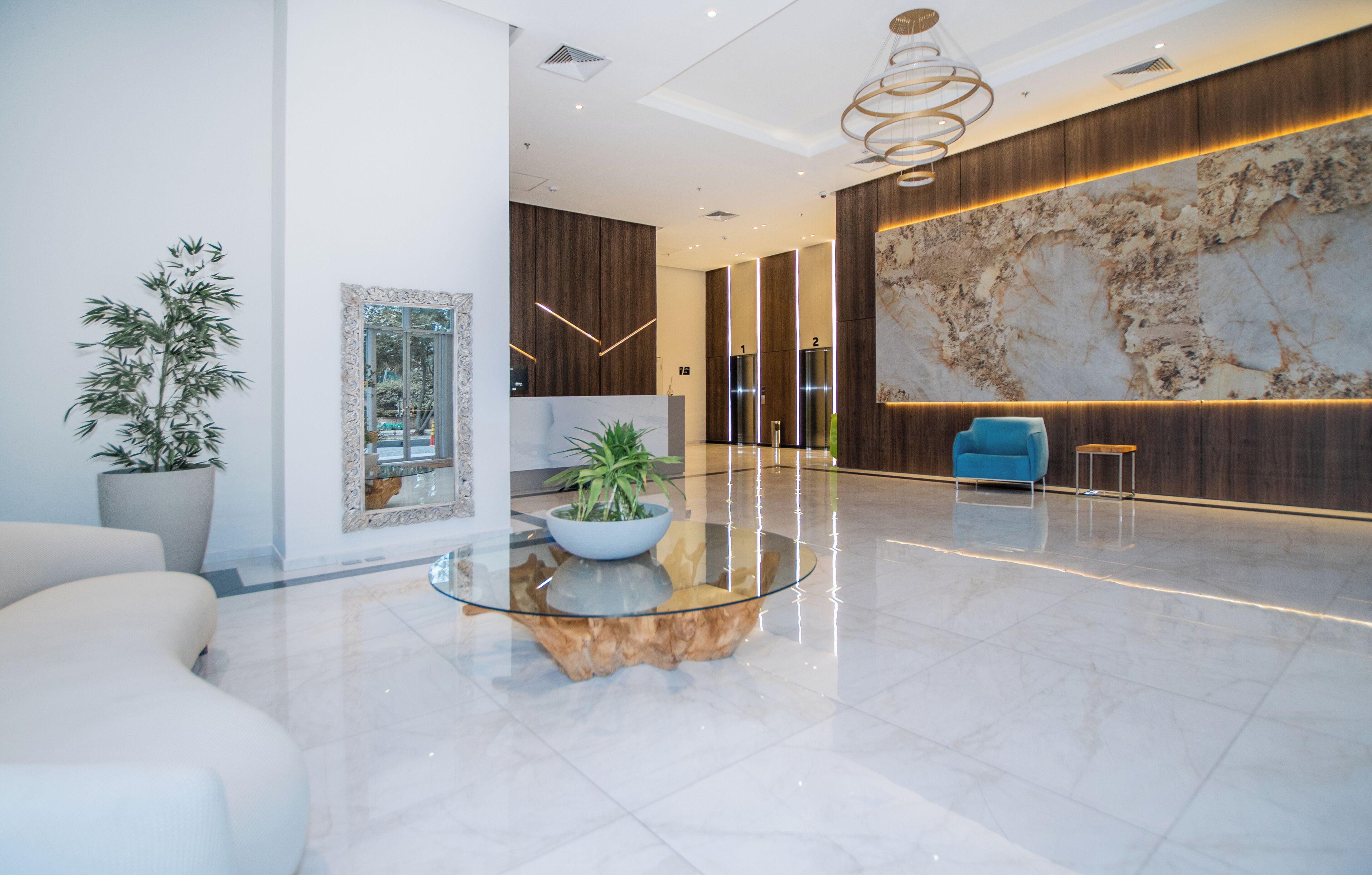 Eine moderne Lobby mit einem мраморнем Empfangstresen, einer großen Wandkarte und einem blauen Sessel.