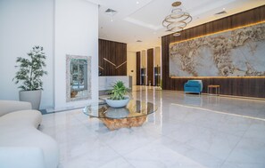 A modern lobby with a marble reception desk, a large wall-mounted map, and a blue armchair. - Luxurious 2-bedroom with gym, pool and AC in the best location of Asunción (Asunción)