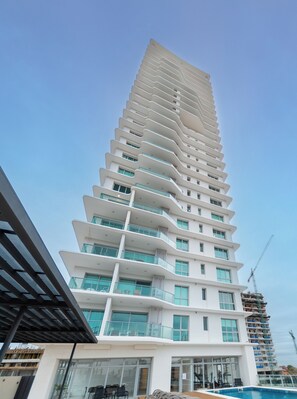 A multi-story hotel with a modern design, featuring balconies and large windows.