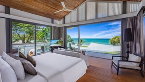 A modern bedroom with a large bed, a TV, and a view of the ocean. - Villa Tievoli (Takua Thung)