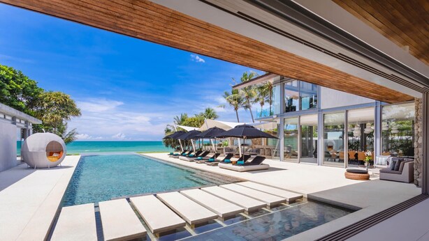 A modern resort with a pool, lounge chairs, and a view of the ocean. - Villa Tievoli (Takua Thung)