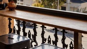 Un balcon donnant sur des immeubles d’habitation et des arbres.