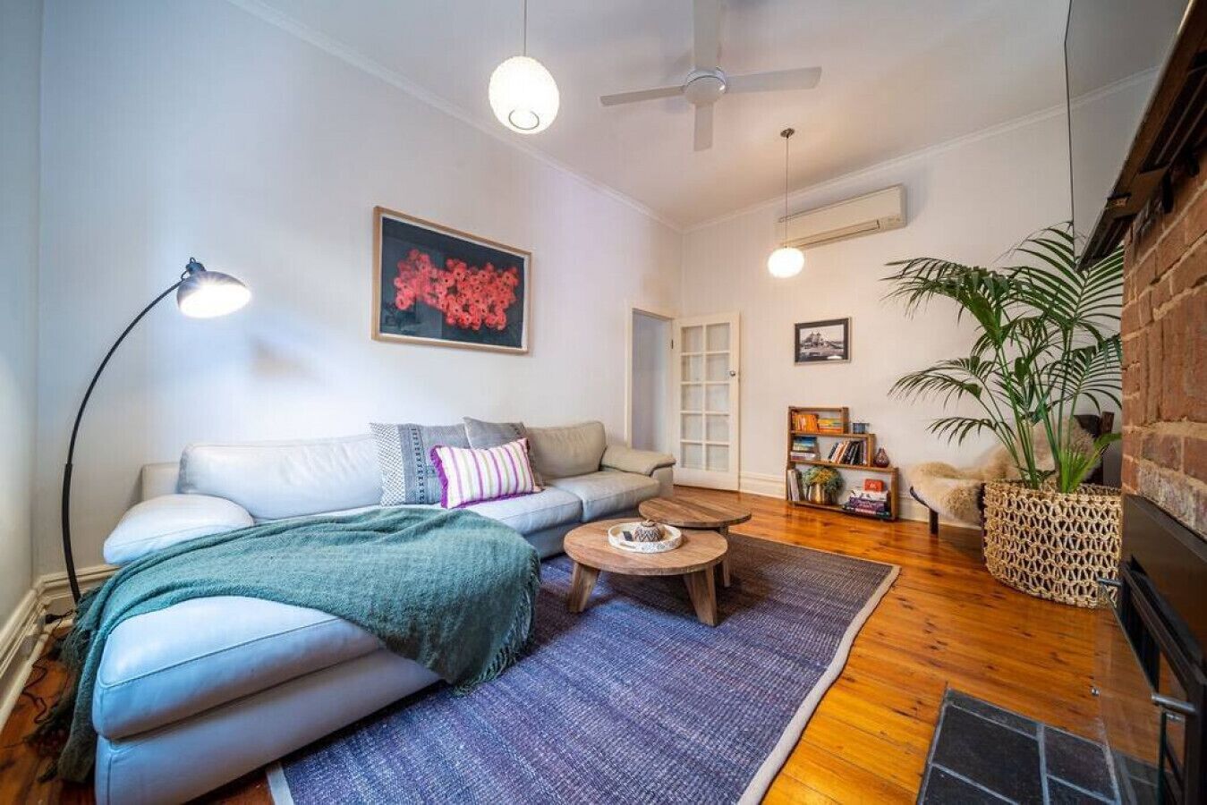 Uma sala de estar aconchegante com sofá, mesa de centro e um vaso de planta.