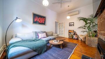 Uma sala de estar aconchegante com sofá, mesa de centro e um vaso de planta.