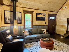 Una sala de estar acogedora con un sofá de cuero, un tapiz estampado y una chimenea.