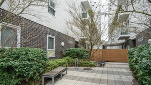 A courtyard with a paved walkway, benches, and a wooden fence. - Get Comfy on Frew - CBD Stay near Parklands & Dining (Adelaide)